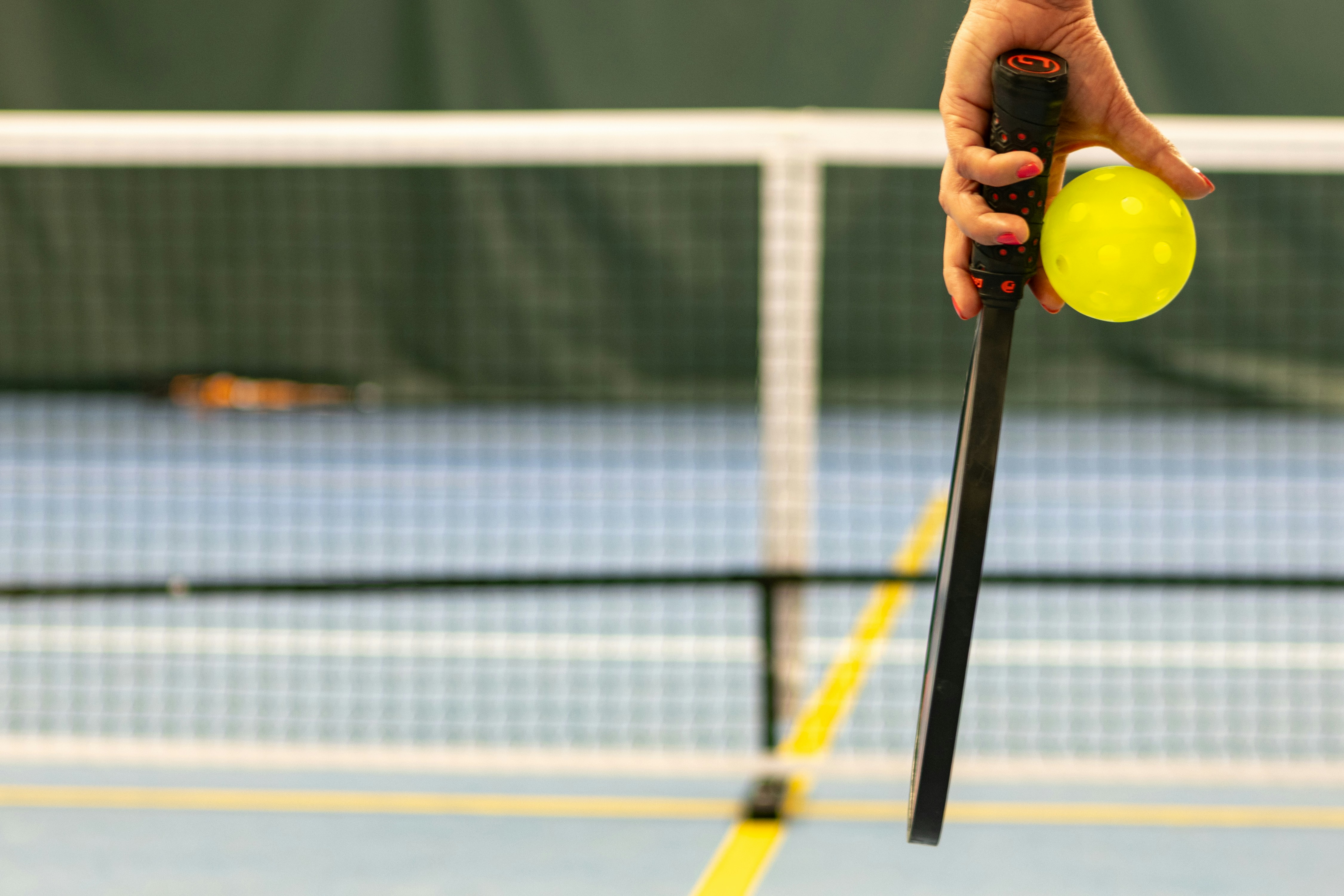 Professional pickleball player in action with premium equipment at Court 1 Club